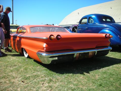 1998 Ford Crown Victoria - Rear three-quarter view of a slammed orange custom car with bullet taillights and a yellow California plate reading EOV 968.