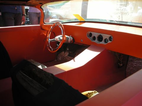 1998 Ford Crown Victoria - Interior of an orange custom car showing a chrome banjo steering wheel, chrome gauge cluster and matching orange door and dash.
