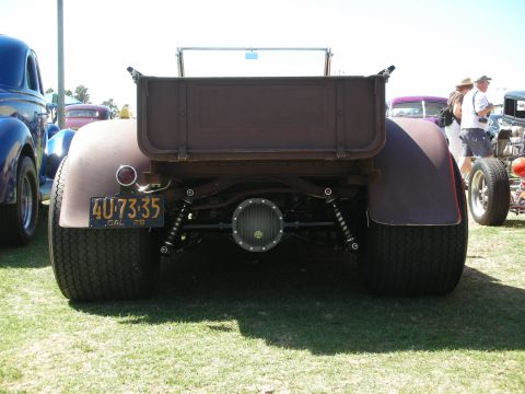 1998 Ford Crown Victoria - Rear view of a primer roadster pickup showing exposed suspension, chrome differential cover and a yellow plate reading 40-73-35 CAL 29.