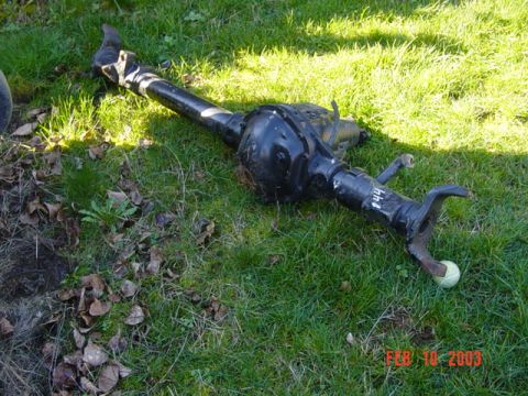 1989 Ford Bronco - A rear axle assembly lies on the grass. The number "F44" is visible on the axle tube.