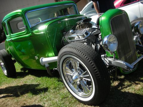1998 Ford Crown Victoria - candy-green metalflake hot rod coupe shows off its chromed exposed V8, whitewall tires and polished five-spoke wheels on grass.