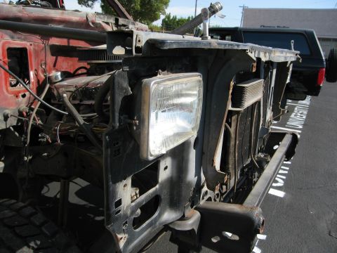 1986 Ford Bronco - Front end of a 1986 Ford Bronco showing exposed engine and radiator, with another vehicle in the background.