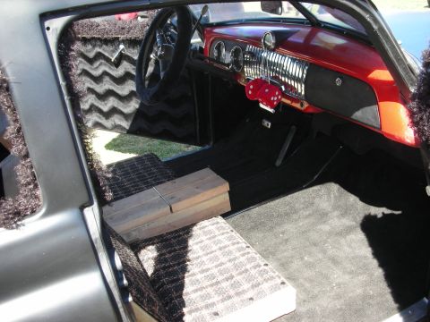 1998 Ford Crown Victoria - stripped custom interior shows an orange-painted dash, fuzzy zebra-print trim, dice shifter and wooden blocks on the floor.