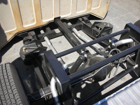1998 Ford Crown Victoria - Detail of a black-painted tubular hot rod frame, rear axle and suspension links seen from behind the cab.