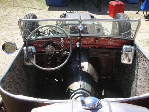 1998 Ford Crown Victoria - View into a hot rod cockpit with pinstriped maroon dash, banjo steering wheel, gauges and leopard-print upholstery.