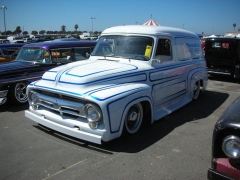 1998 Ford Crown Victoria - lowered white classic Ford panel delivery truck with blue pinstripe scallops and chrome grille at an outdoor show.