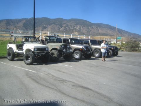 1987 Suzuki Samurai - A lineup of off-road vehicles, including a Suzuki Samurai and multiple Jeeps, are parked in a lot.