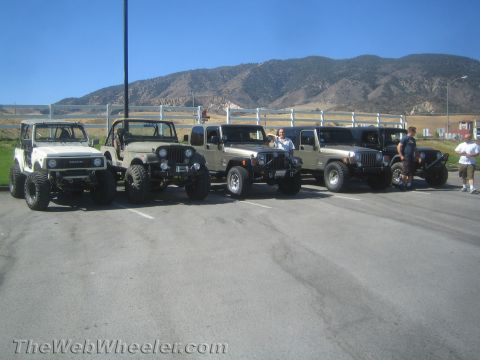 1987 Suzuki Samurai - A white 1987 Suzuki Samurai is parked in a lot with several Jeeps on a sunny day.