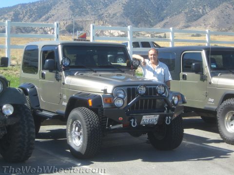 1987 Suzuki Samurai - A man poses with a tan Jeep Wrangler, which appears to be a TJ model from the early 2000s, parked next to another Jeep.