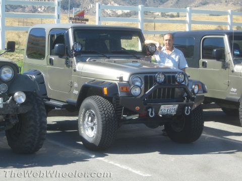1987 Suzuki Samurai - A man poses with his modified Jeep Wrangler, parked alongside another Jeep.