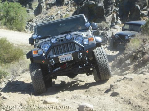 1987 Suzuki Samurai - Two Jeeps tackle a challenging off-road course with rocky terrain and steep inclines.