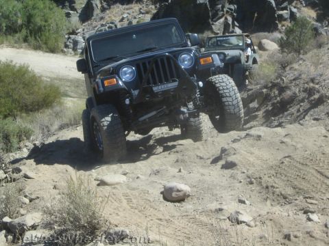 1987 Suzuki Samurai - Two Jeeps navigate a challenging, rocky off-road trail.
