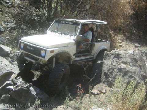 1987 Suzuki Samurai - Suzuki Samurai tackling a challenging rocky path on a trail.