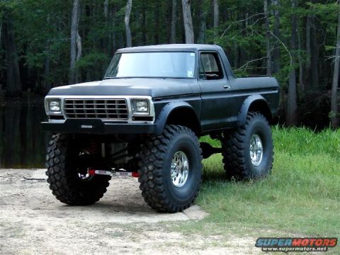 1978 Ford Bronco - Modified 1978 Ford Bronco with significant lift and oversized tires sits in a natural setting.
