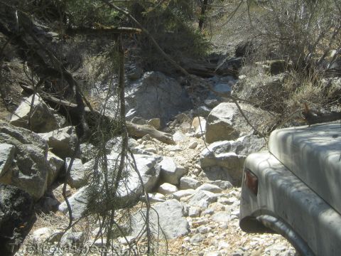 1987 Suzuki Samurai - Navigating a rough, rocky trail with a portion of a vehicle visible.