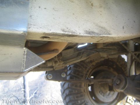 1987 Suzuki Samurai - The underside of a vehicle shows its suspension and exhaust system.