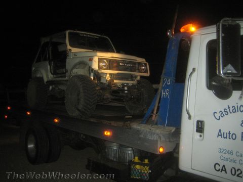 1987 Suzuki Samurai - Suzuki Samurai loaded onto a tow truck at night, with 'SUZUKI' visible on the grille.
