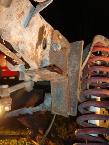 1996 Ford F-150 - Close-up of rusted suspension components and a red coil spring, likely from a truck.