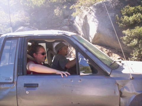 1989 Ford Bronco - People ride in a damaged truck during an off-road excursion.