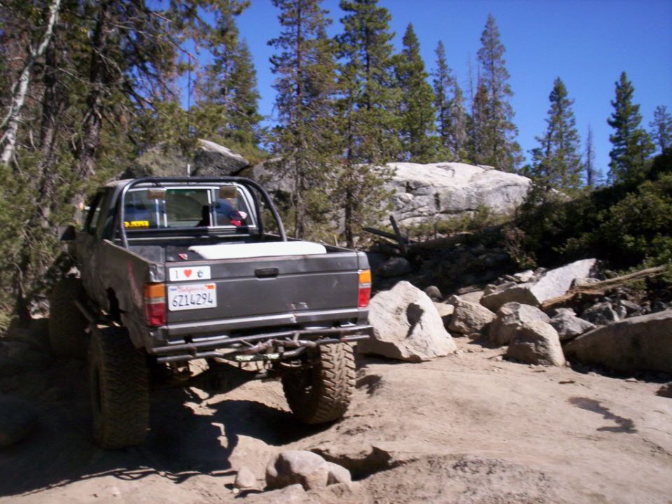 Pickup truck on rocky trail, rear view. License plate reads 6Z14294