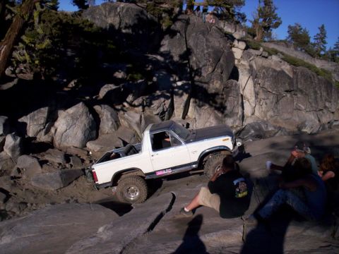 1989 Ford Bronco - Ford Bronco tackling a difficult off-road course with spectators observing.