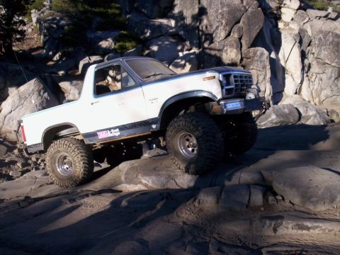 1989 Ford Bronco - This modified Ford Bronco is navigating a rocky trail, its off-road capabilities.