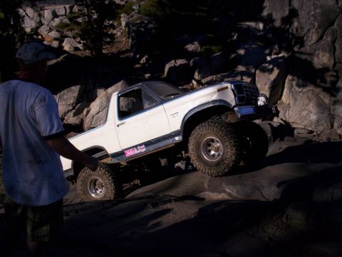 1989 Ford Bronco - This modified Ford Bronco navigates a rocky trail, displaying a "NO LIMIT 4x4" sticker on its side.