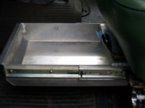 1978 Ford Bronco - Shop-fabricated bare aluminum storage tray pulled out on ball-bearing drawer slides, mounted to the floor of a vehicle next to a green viny…