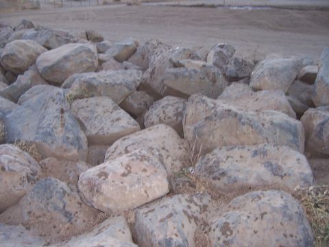1991 Ford Bronco - A close-up view of a jumbled pile of large, weathered rocks with sparse dry grass.