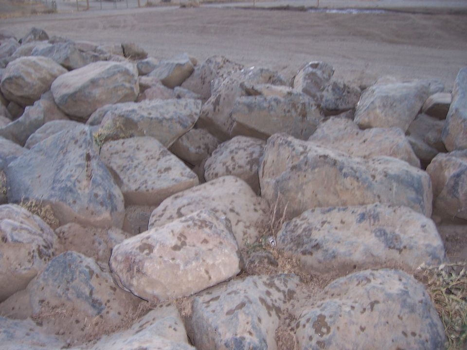 pile of large rocks with dry grass