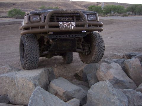 1991 Ford Bronco - A dirty Toyota SUV navigates a rocky obstacle course.