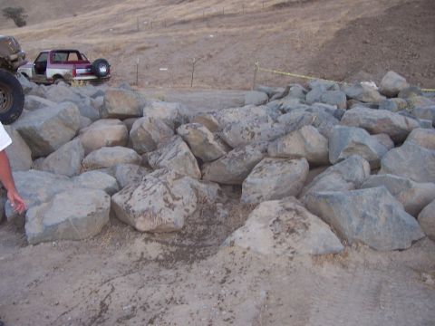 1991 Ford Bronco - A red and white Ford Bronco is visible behind a pile of large rocks.