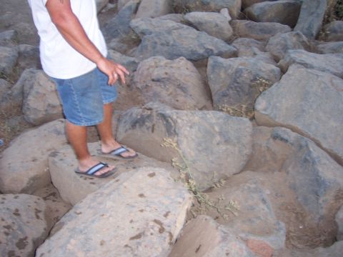 1991 Ford Bronco - A person stands on a rocky terrain, wearing denim shorts and flip-flops.