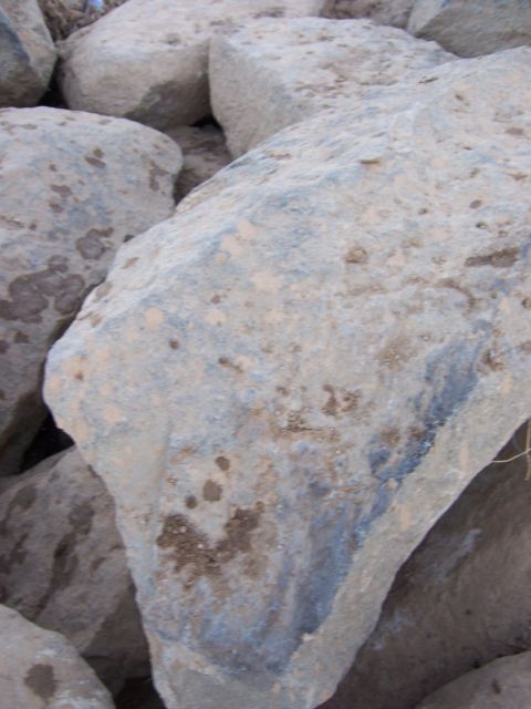 1991 Ford Bronco - A collection of large, rough rocks dominate the frame, showing signs of dirt and mud accumulation.