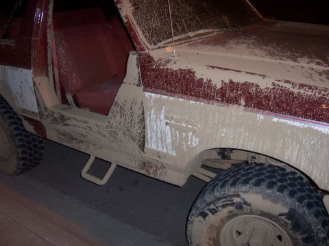 1991 Ford Bronco - This 1991 Ford Bronco is heavily covered in mud, obscuring most of its original paint and details.