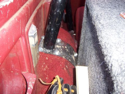 1991 Ford Bronco - A roll bar is mounted inside the vehicle, secured with bolts and metal brackets.