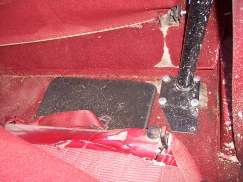 1991 Ford Bronco - Close-up view of the interior floor and seatbelt mechanism, with a visible roll bar support.