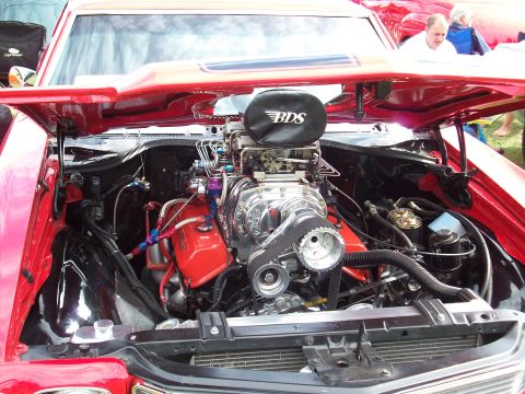 1997 Ford Mustang - Engine bay of a red car with a prominent BDS supercharger and custom modifications.
