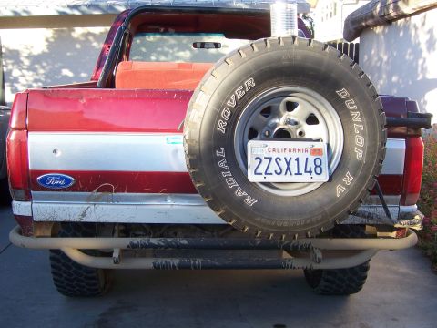 1991 Ford Bronco - The rear of a red 1991 Ford Bronco is visible, a spare tire and a California license plate.