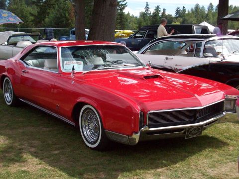 1997 Ford Mustang - A red classic coupe with whitewall tires and chrome accents is displayed outdoors.