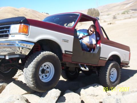 1991 Ford Bronco - 1991 Ford Bronco navigating rocky terrain on a sunny day.