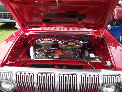 1997 Ford Mustang - Engine bay of a classic car dual carburetors and a prominent chrome grille.