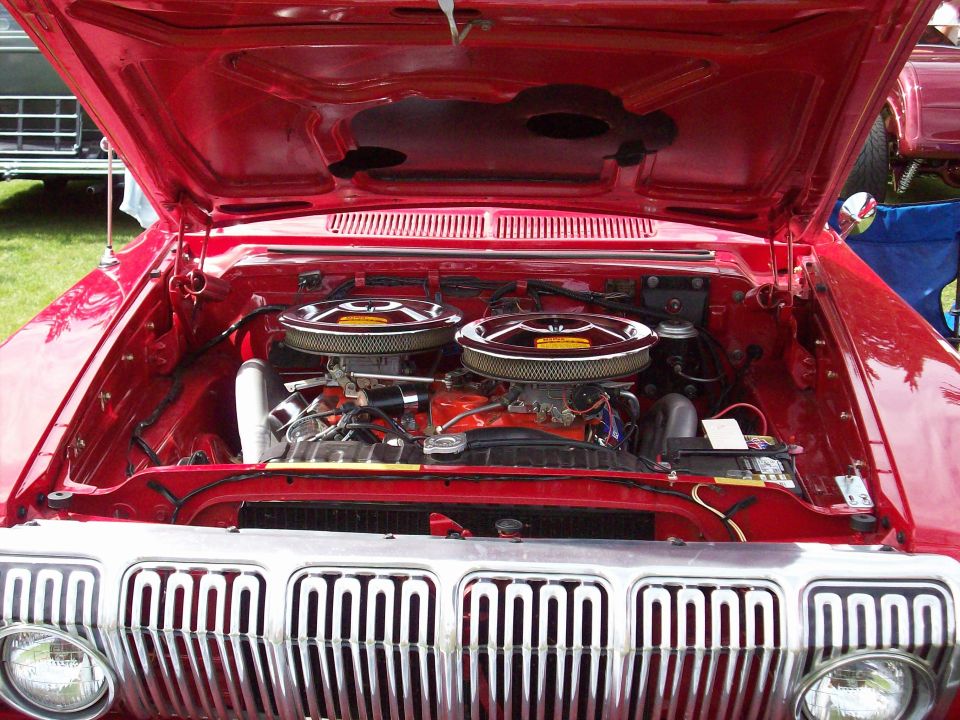 Red engine bay with dual carburetors and chrome grille