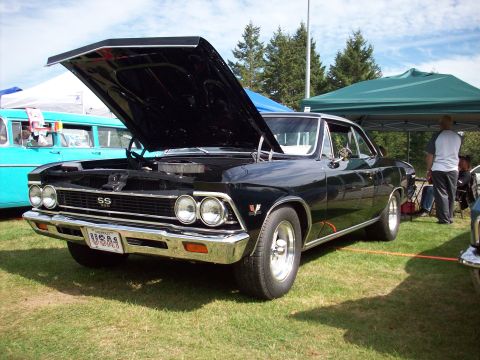 1997 Ford Mustang - This black 1966 Chevelle SS is displayed with its hood up at an outdoor car show.