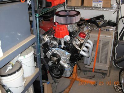 1980 Ford Bronco - V8 engine assembly with aftermarket air cleaner and exhaust headers, mounted on an engine stand.