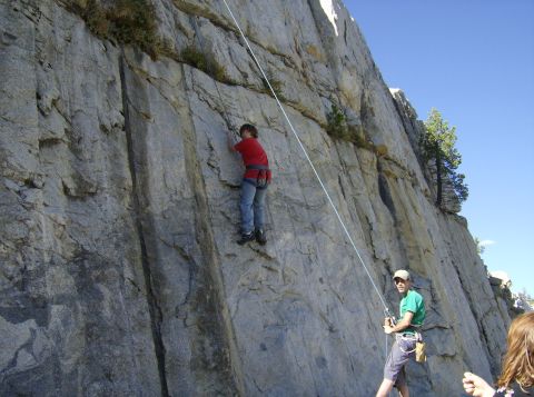 1986 Ford Bronco - A climber ascends a steep rock wall while a belayer manages the rope below.
