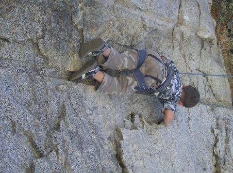 1986 Ford Bronco - Climber scales a large rock formation using a harness and rope for safety.