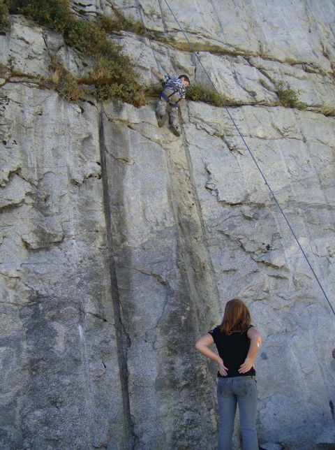 1986 Ford Bronco - A climber is being belayed down a steep rock face while another person observes the descent.