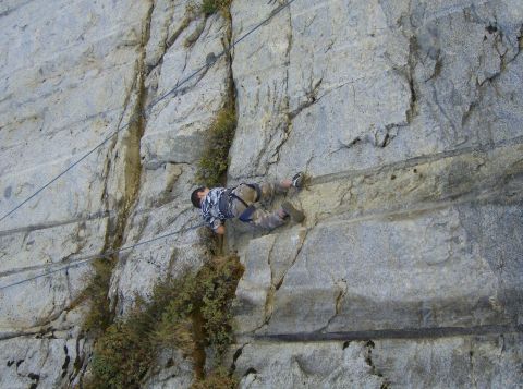 1986 Ford Bronco - A rock climber scales a sheer cliff face, utilizing ropes and climbing gear for ascent.