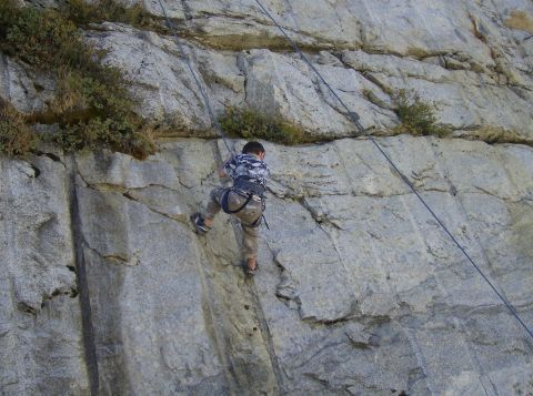 1986 Ford Bronco - A person is ascending a rock face, using climbing gear for safety.